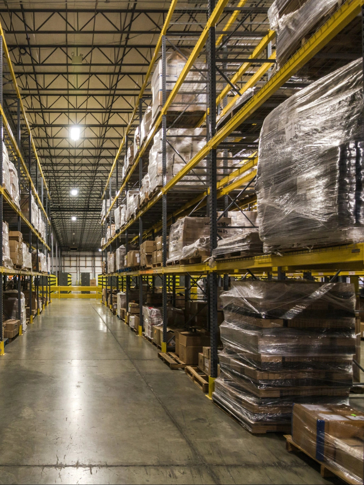 Warehouse shelving with storage boxes and wrapped pallets, ready for Sunaofe distribution.