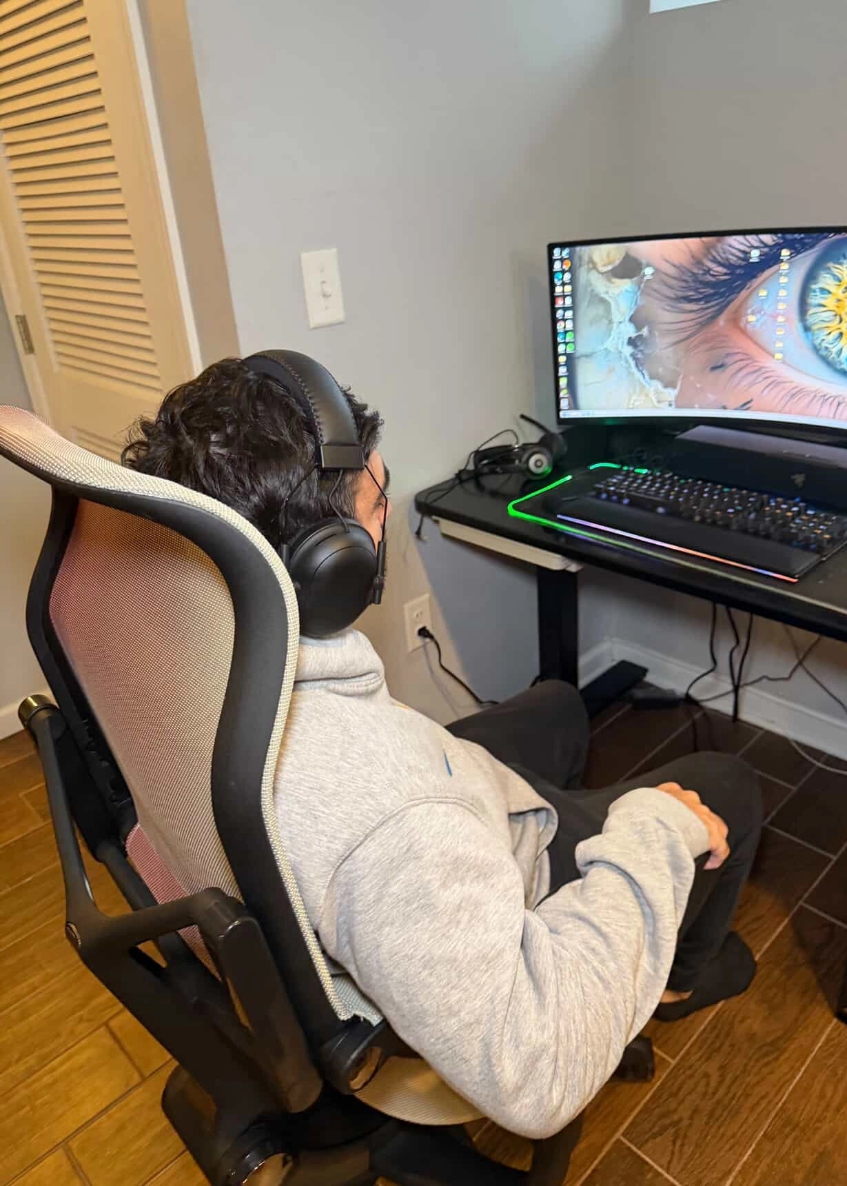 A user enjoys the comfort of a Sunaofe ergonomic mesh chair and height-adjustable desk in a modern home office.