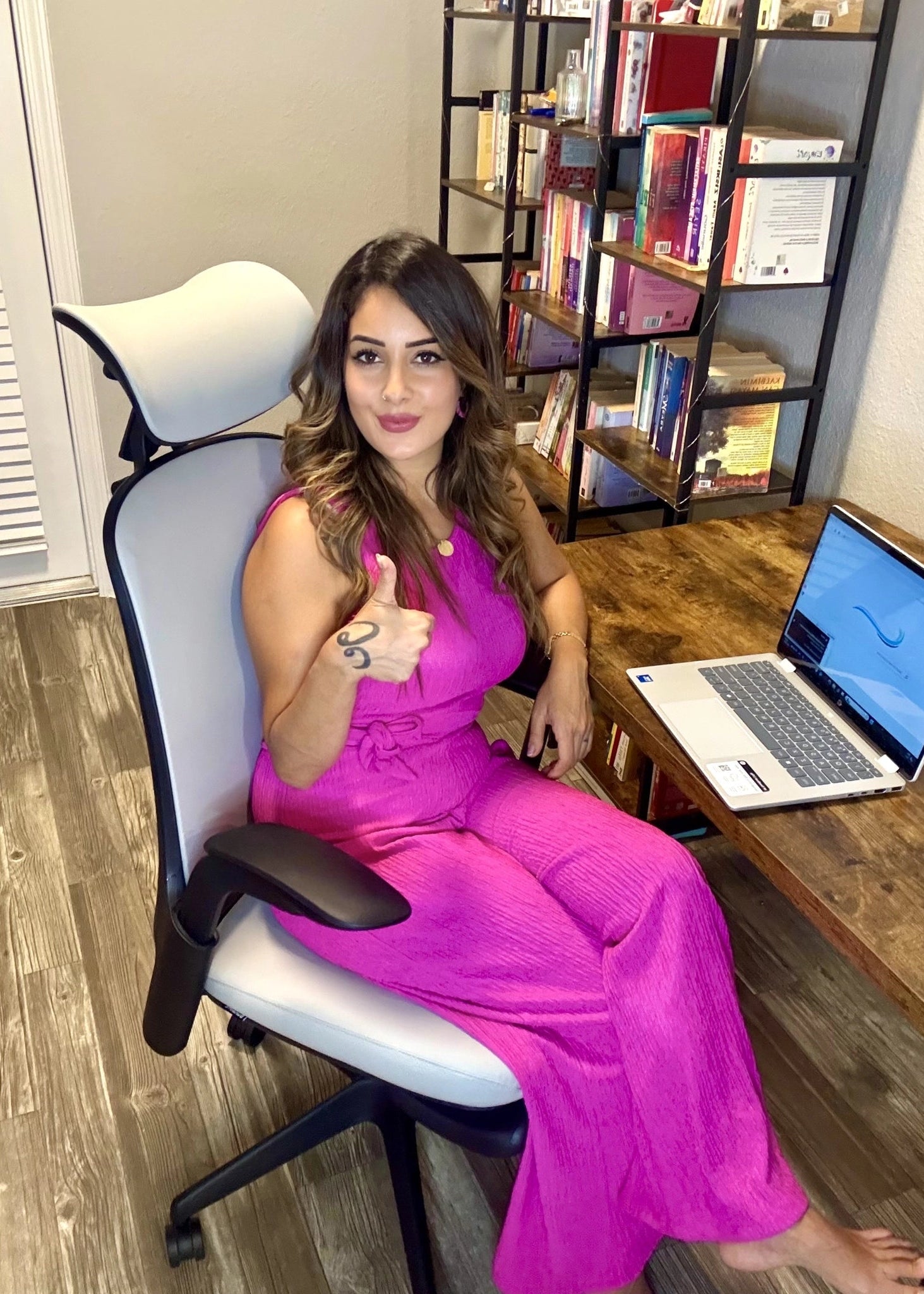 A woman gives a thumbs up while sitting in a comfortable Sunaofe ergonomic office chair in her home workspace.